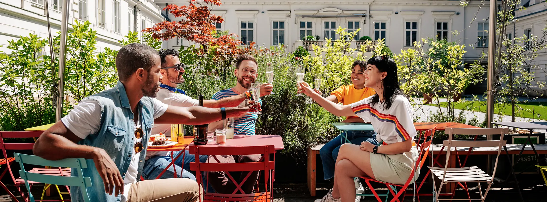 Fiatalok csoportja együtt iszik egy Schanigarten kerthelyiségben